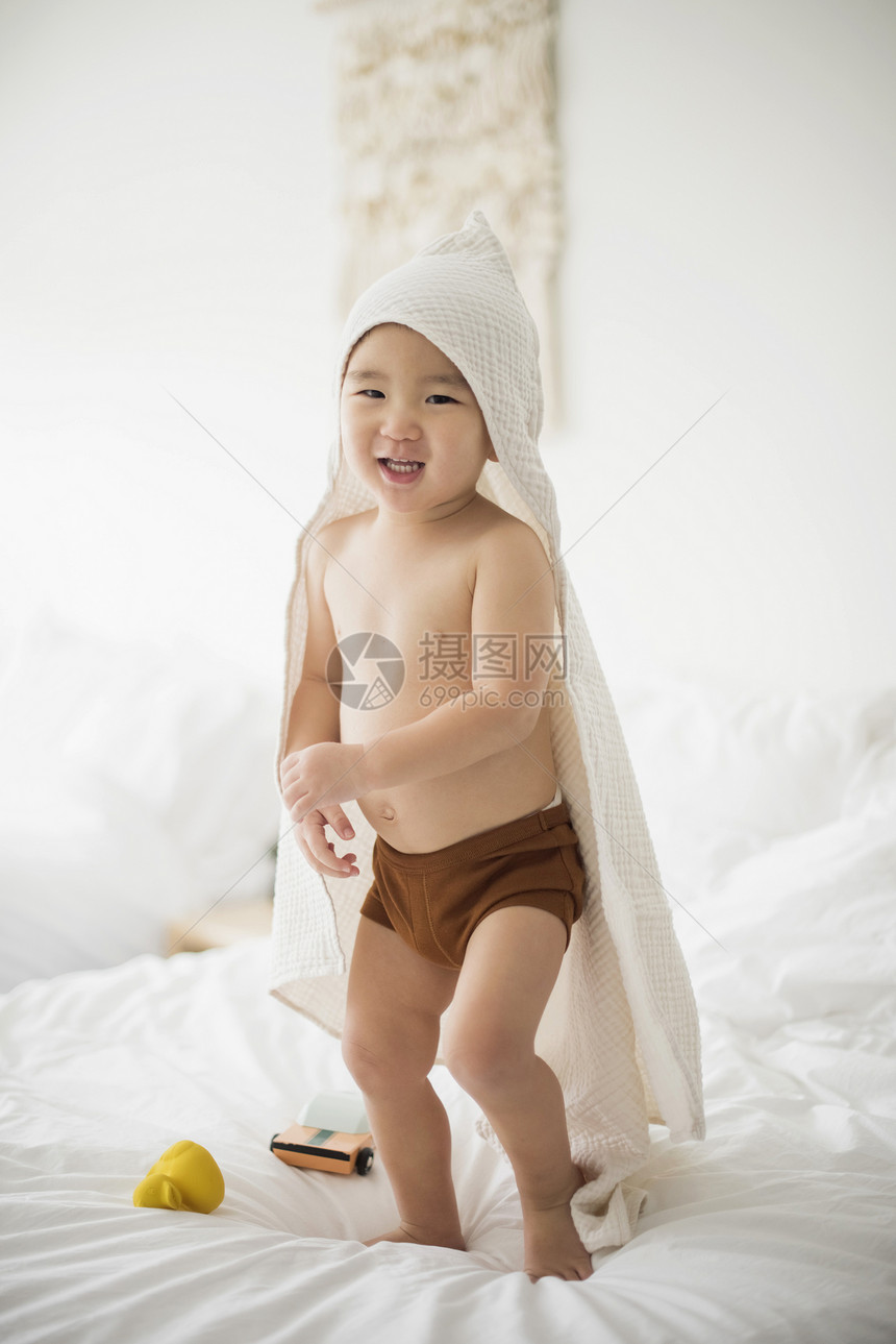 小男孩在床上戴着毛巾图片