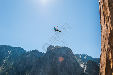 在美国加利福尼亚州约塞米特河谷基地的山丘上跳到半空的人图片