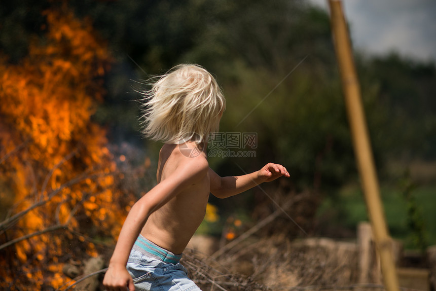 金发男孩从着火的花园中逃出图片