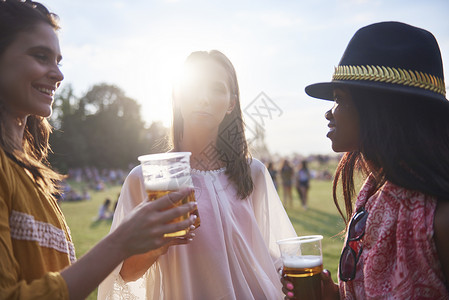 卡托维兹三个年轻的女朋友在霍利节带杯啤酒背景