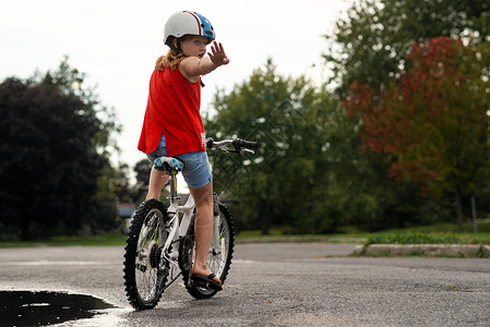 骑自行车的女孩停在路中间图片