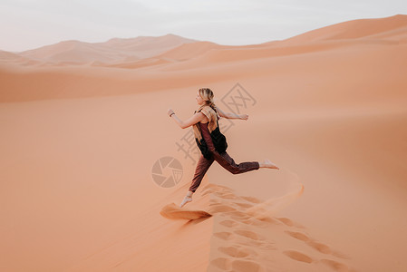 在沙漠中奔跑的妇女摩洛哥杜巴图片