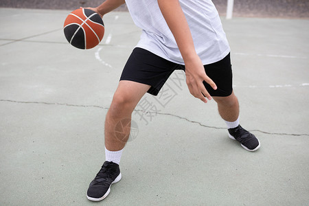 男青少年篮球运动员在法庭上打篮球腰部下图片