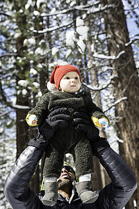 父亲在美国加利福尼亚州湖南边冬季森林举起男婴儿图片