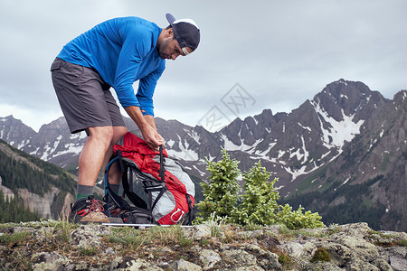 美国科罗拉多州欧莱斯内弗勒山收拾背包的登山者图片