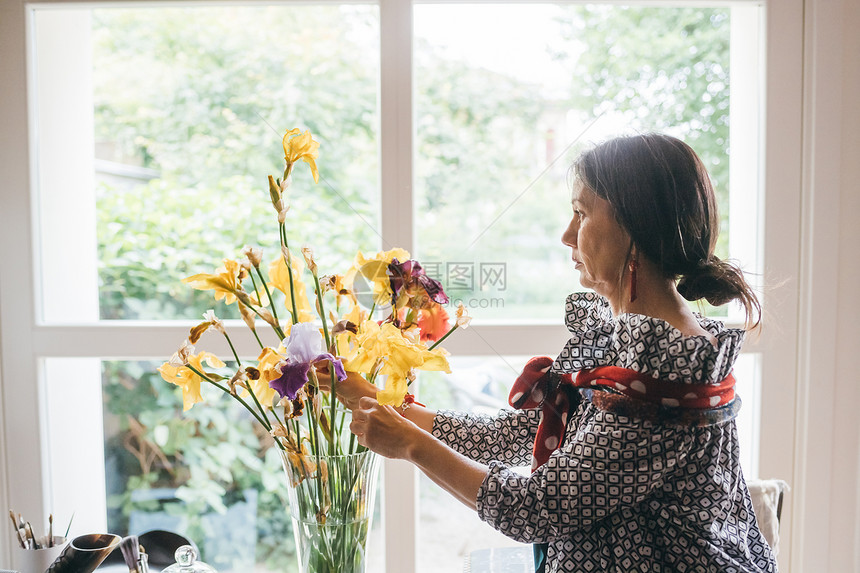 妇女用花瓶装花图片