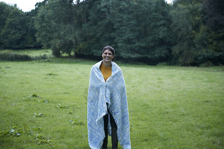 年中成妇女站在农村田里用毛毯包着全长的肖像片图片