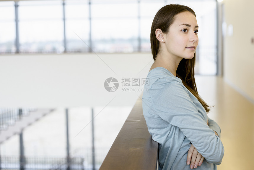 靠在栏杆上的年轻女人图片