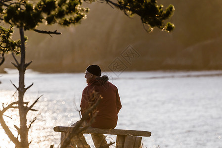 加拿大约翰斯通海峡湖边长凳上看风景的男人高清图片