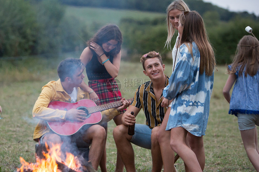 年轻人在公园的营火派对上弹吉他唱歌图片