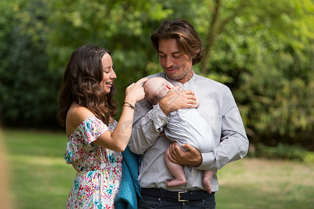 丈夫和妻子在花园中和宝宝互动图片