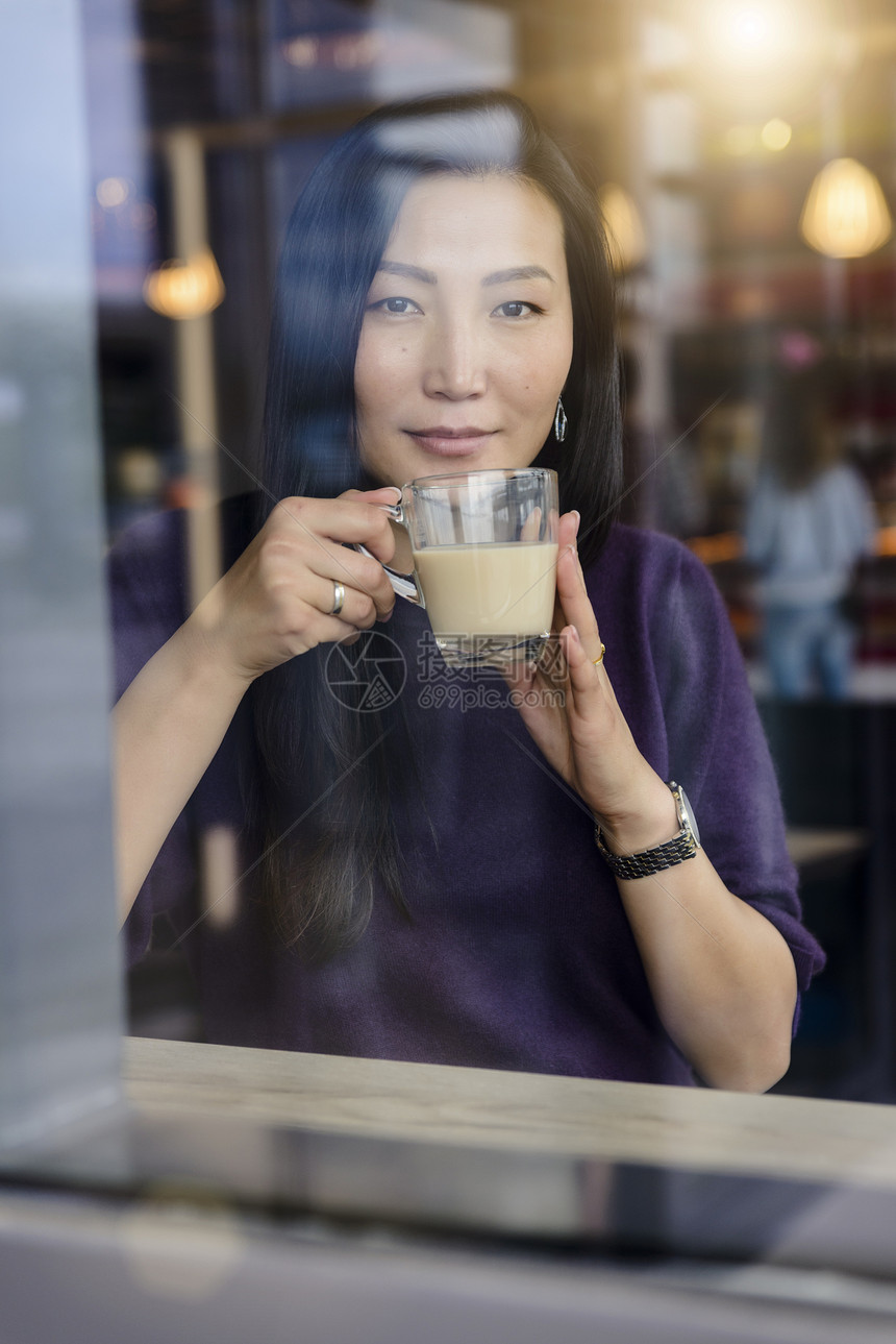 成年女人从咖啡厅窗口向外看图片