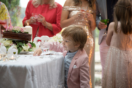 男孩子对婚礼堂的物和蛋糕很好奇高清图片