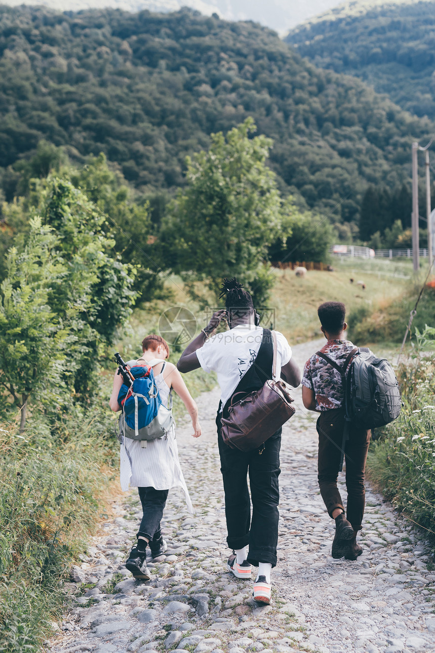 年轻的成年徒步旅行者朋友们沿着乡村鹅卵石路徒步旅行后视图普里马卢纳特伦蒂诺阿尔托阿迪奇意大利图片