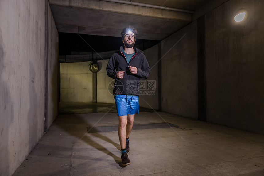 隧道里戴头灯的男人在跑步图片