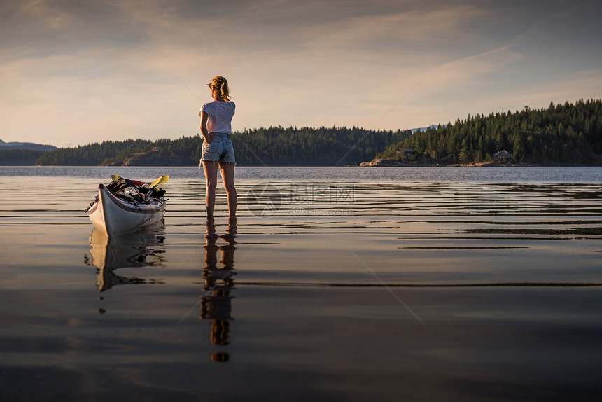 加拿大坎贝尔河岛站在湖边皮划艇旁眺望的年轻女子图片