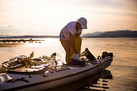加拿大坎贝尔河日落时准备皮艇的人图片