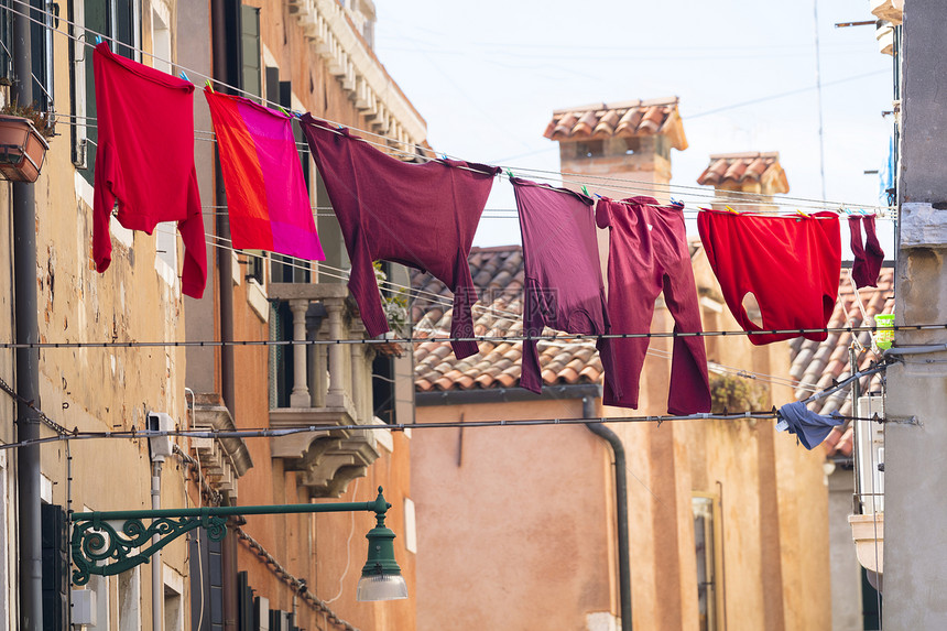 意大利威尼斯维内托维内托外传统住宅的衣着线上穿红色和粉衣服图片