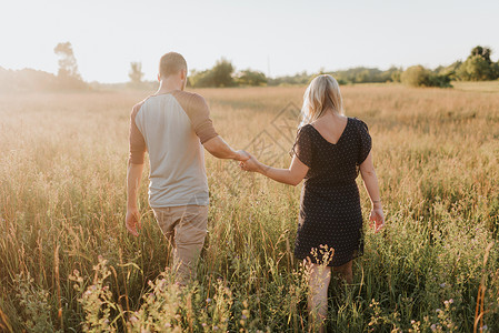 浪漫的男人和女友在长草丛中漫步图片