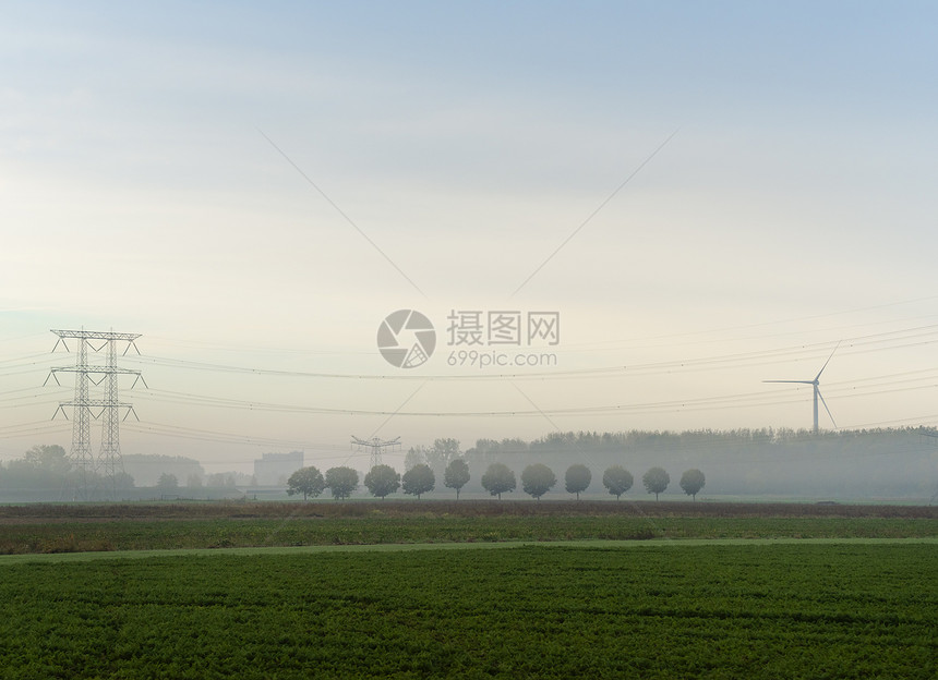 风力涡轮机和电线在雾的早晨风景荷兰图片