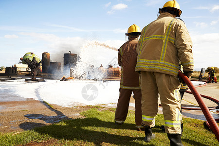 消防员培训团队在培训设施喷洒消防泡沫背景图片