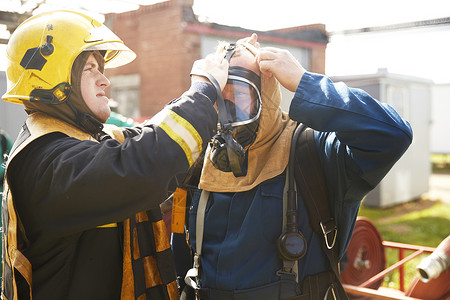 消防员培训督导在设施帮助消防员使用呼吸设备图片