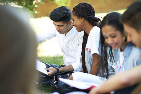 高等教育学生在大校园草坪上看文案背景图片