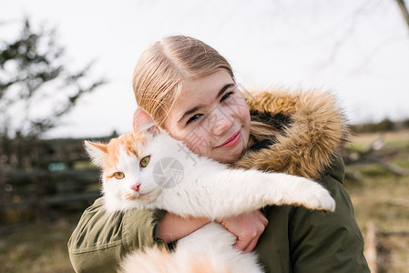 女孩在田里抱着猫看镜头图片