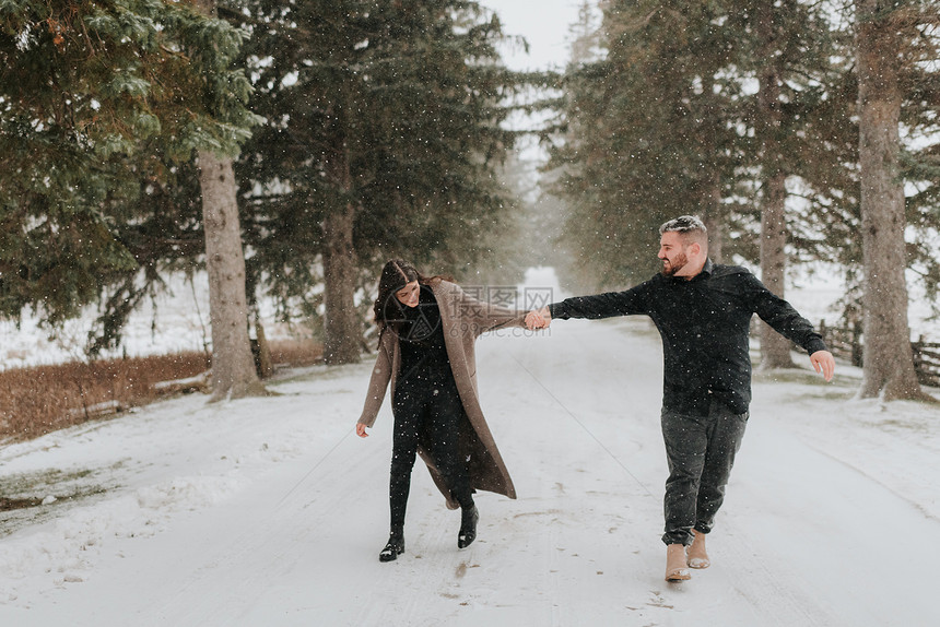 在加拿大乔治敦的雪地上牵手行走的情侣图片