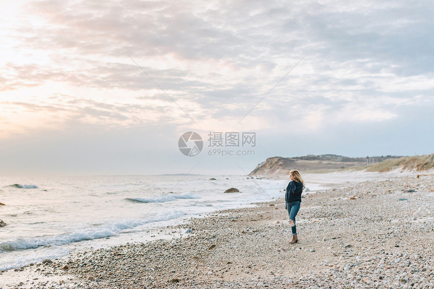 美国马萨诸塞州玛莎葡萄园梅内姆沙一名年轻女子在海滩眺望大海图片