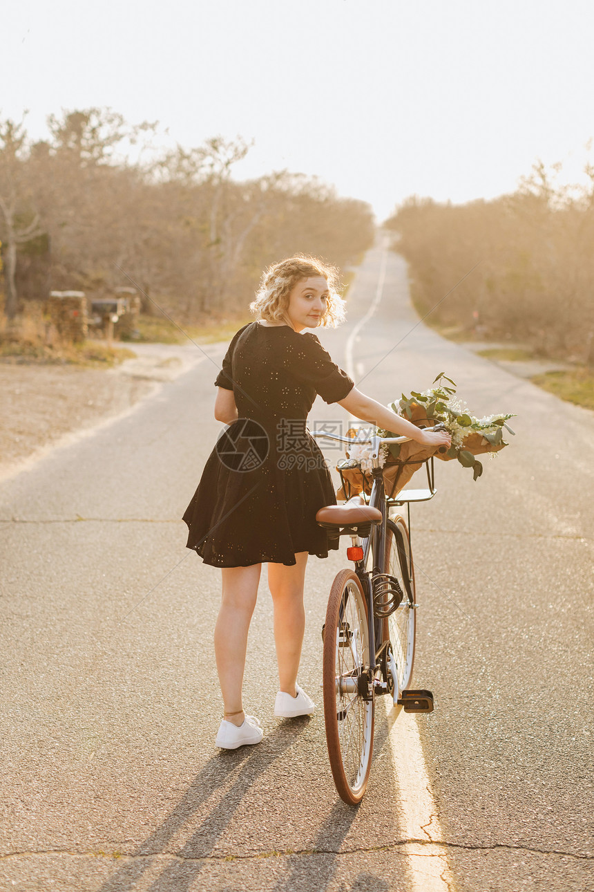 农村公路上推自行车的年轻女子图片
