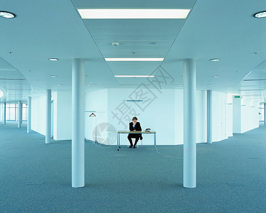 空旷的办公室里工作的商人图片