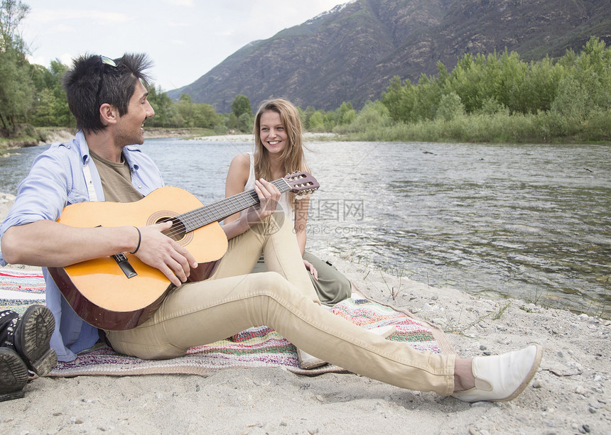 坐在河边玩吉他的朋友图片