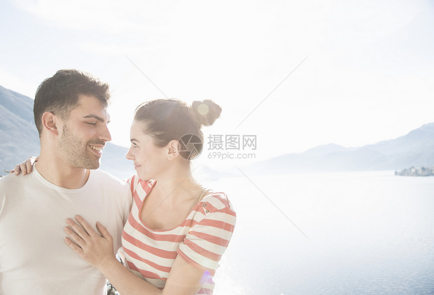 在湖和山前的年轻夫妇图片