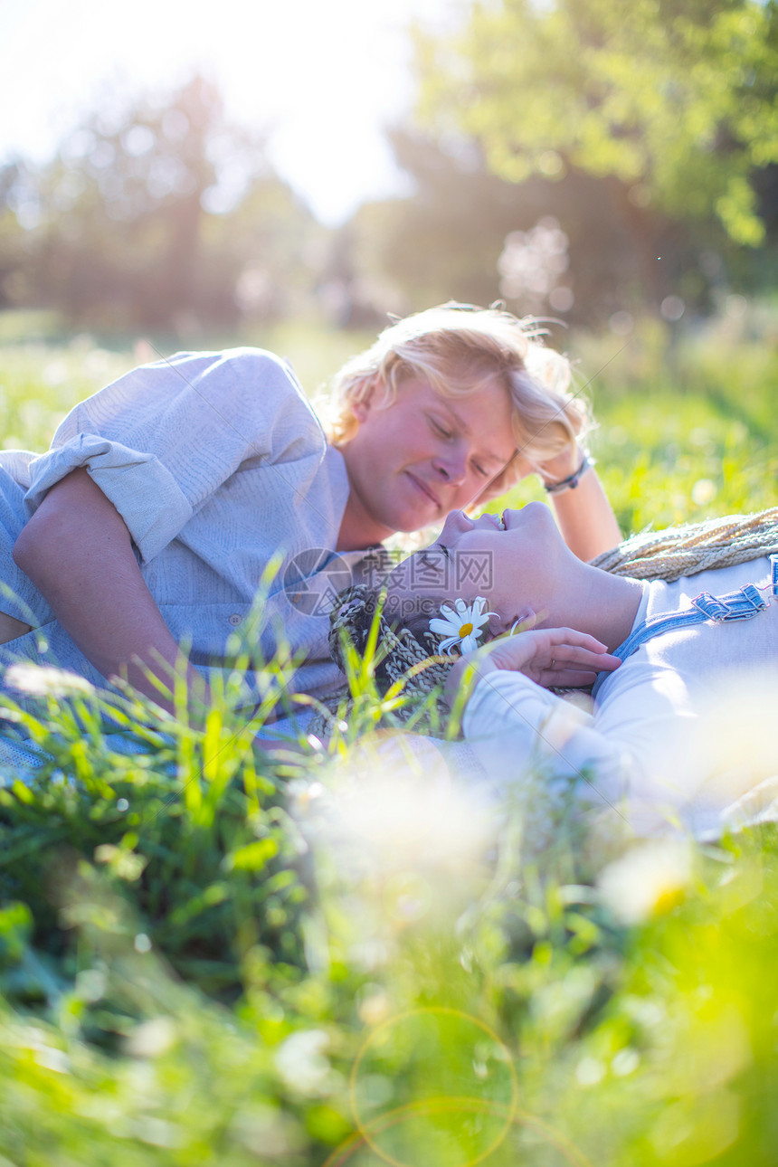 西班牙一起躺在草地上的年轻夫妇图片