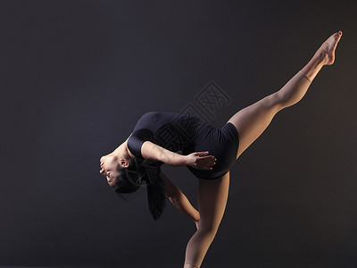 年轻女舞低关键镜头站在一条腿上向后弯曲图片