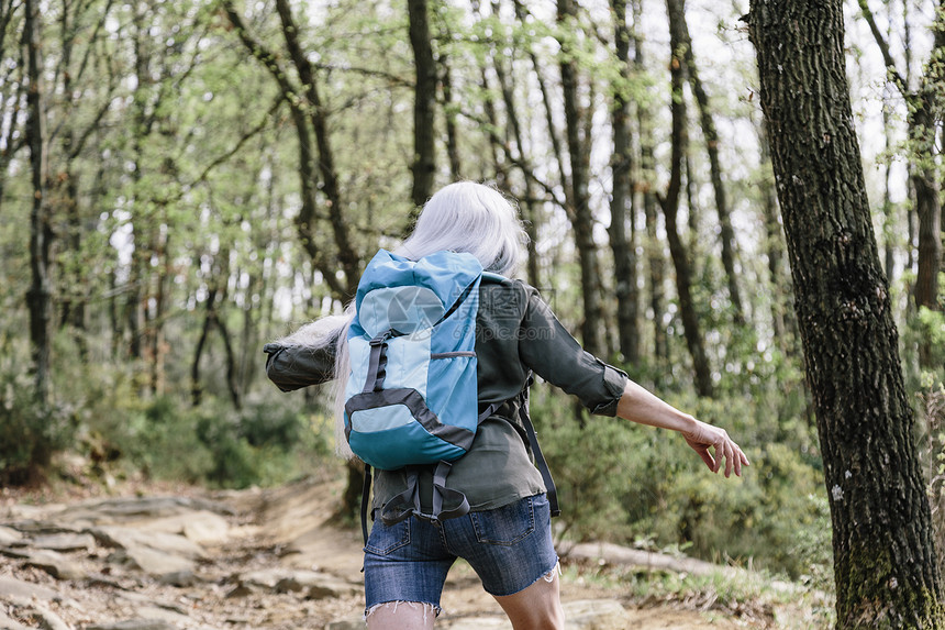 意大利托斯卡纳Scandicci森林中成年女背包车行走近视景图片