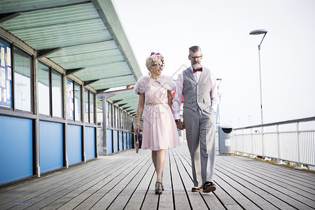 在码头打扮复古的情侣手牵手散步图片