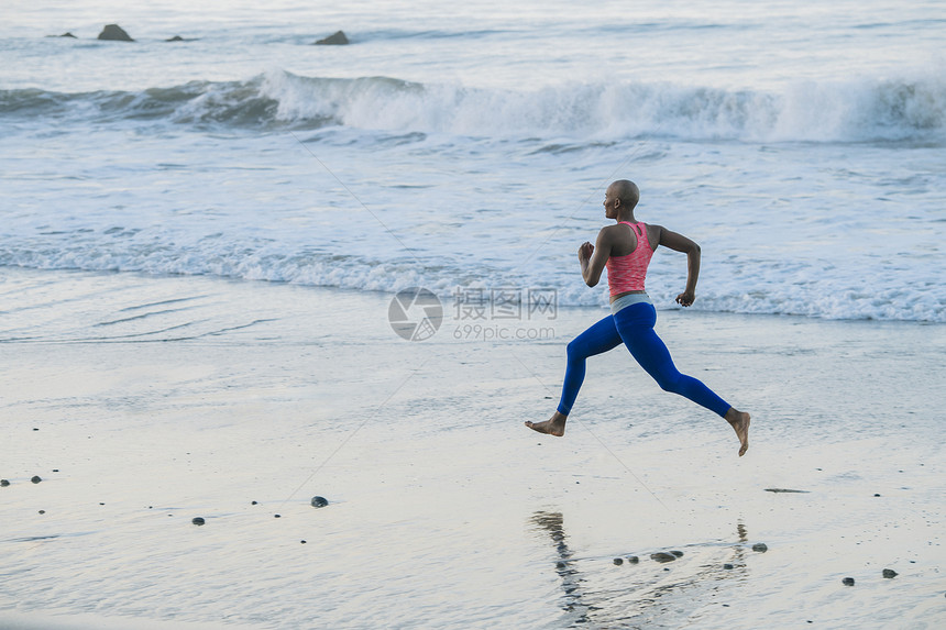 年轻女子在海滩上运动跑步图片