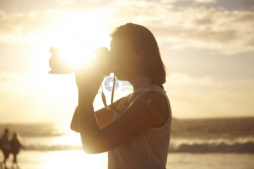 南非西开普省海边日落时的年轻女摄影视图图片
