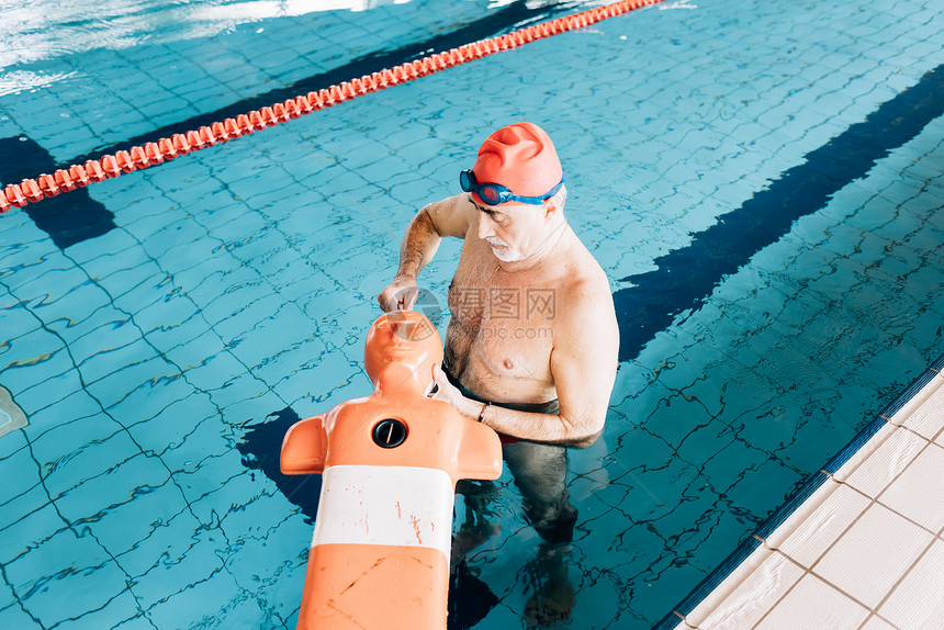 高级男子在游泳池做救生培训图片