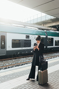 意大利米兰火车站使用移动电话的女商人图片
