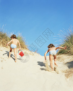 双胞胎在沙滩上奔跑图片