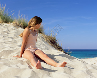 女孩坐在沙滩上图片