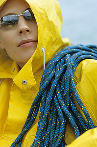 穿黄色雨衣和墨镜的女人肩上挂着绳子背景图片