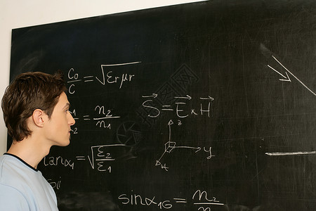 年轻人在考虑黑板上的方程式图片