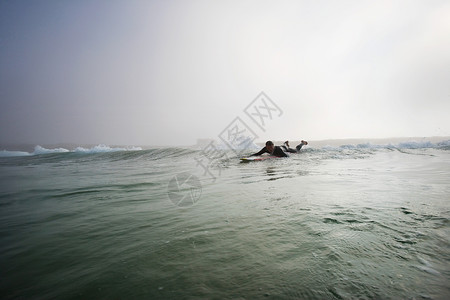 人躺在水中的冲浪板上图片