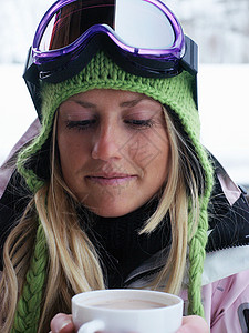 穿着滑雪装的年轻女子用杯装图片