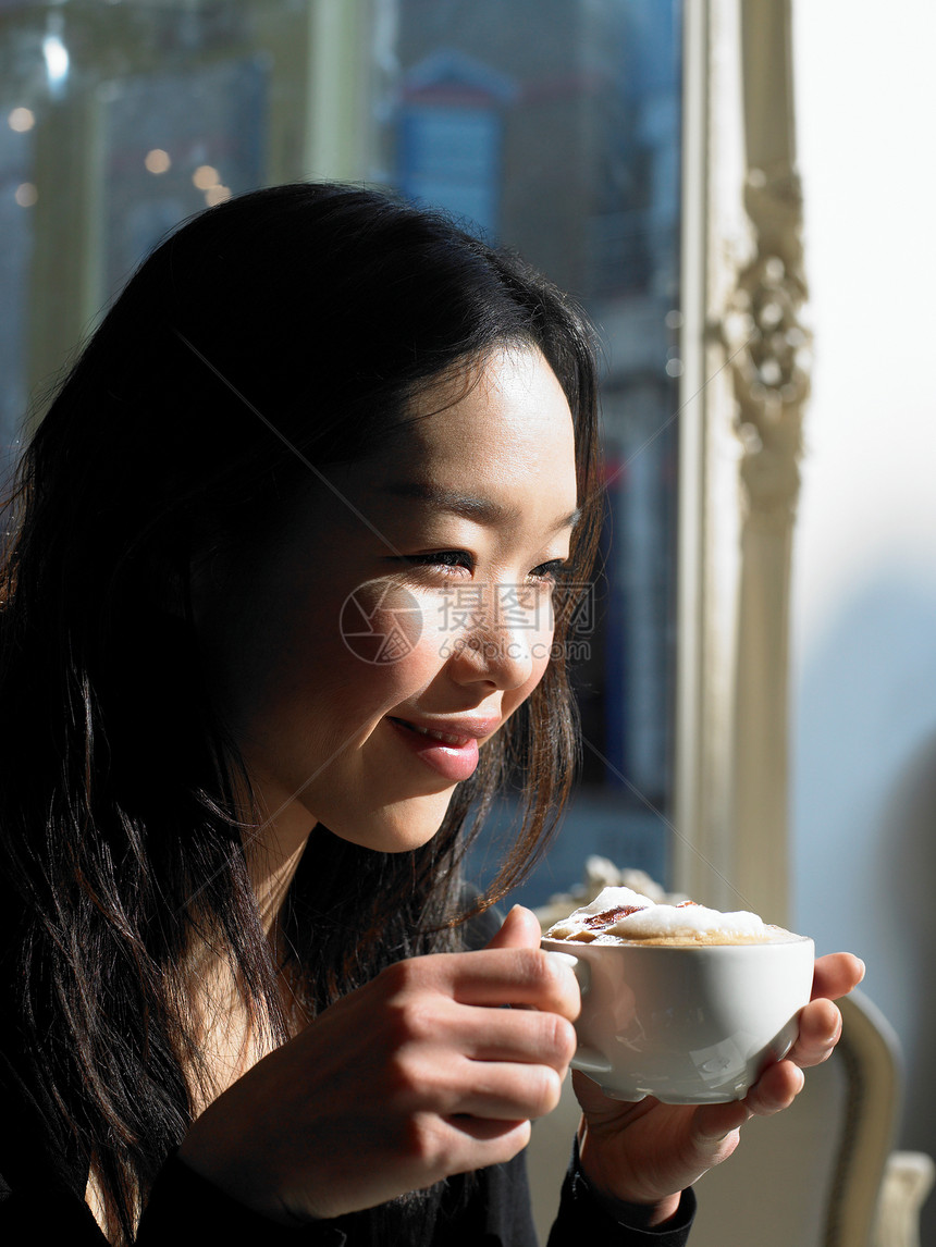 带着卡布奇诺笑容的年轻女子图片