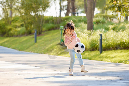 阳光下玩足球的小女孩高清图片